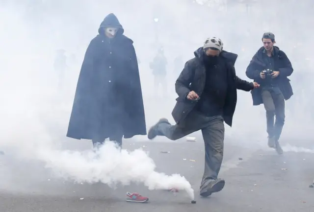 Protester kicking a tear gas canister