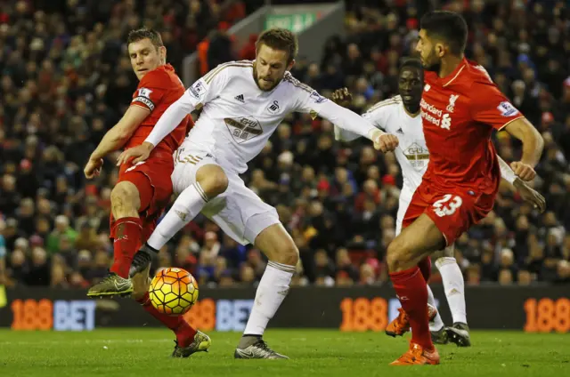 Gylfi Sigurdsson in action with Liverpool's Emre Can and James Milner