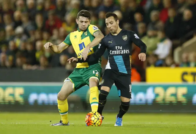 Arsenal's Santi Cazorla challenges for the ball with Norwich's Robbie Brady