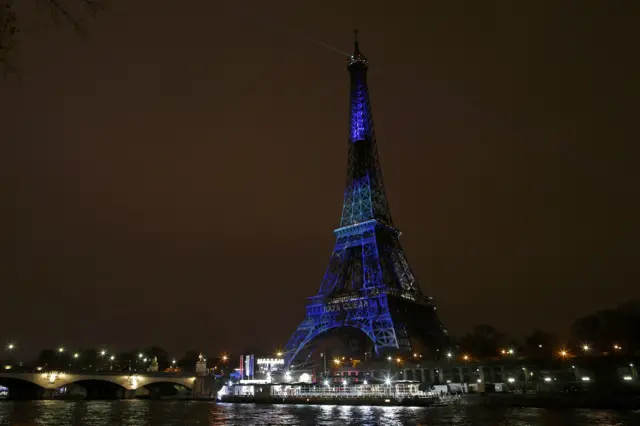 Eiffel Tower lit up in green and blue