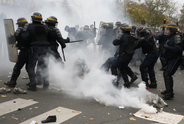 Riot police setting off tear gas