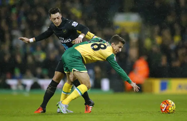 Arsenal's Mesut Ozil and Norwich's Gary O'Neil challenge for the ball