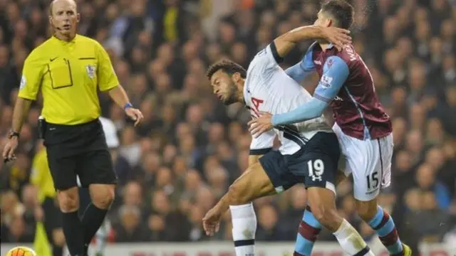 Mike Dean looks on as Ashley Westwood suffers his head injury