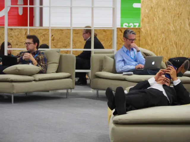 delegates checking phones and typing on lounges