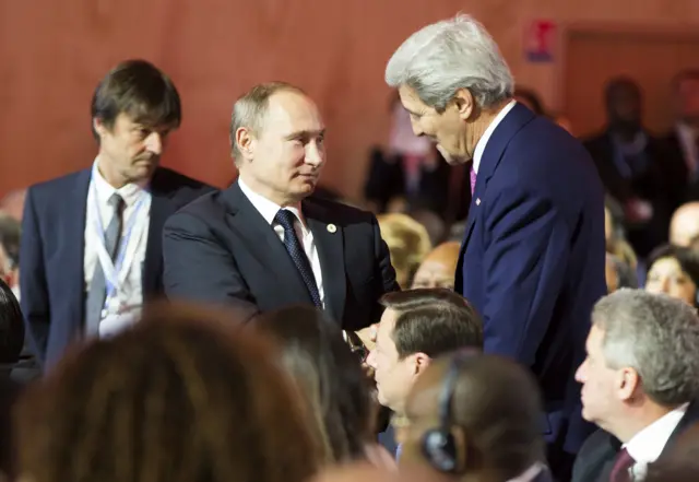 Vladimir Putin and John Kerry shake hands