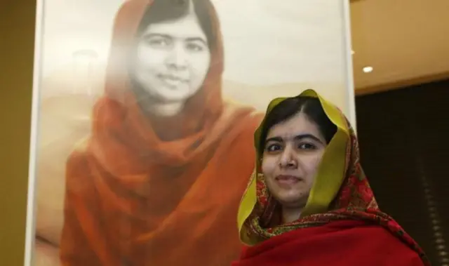 Malala Yousafzai next to the portrait