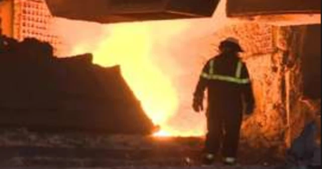 Worker in protective clothing in steel works