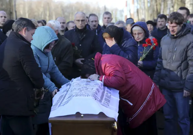 Mourners next to a coffin of Alexei Alexeev, a victim of the crash