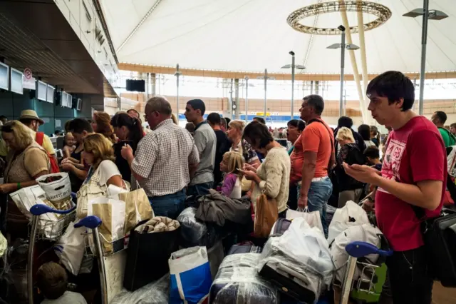 Passengers gather at Sharm el-Sheikh airport a a number of flights are suspended