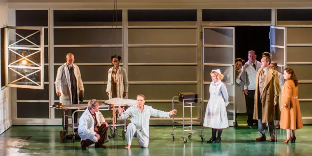 Orlando kneeling surrounds by the rest of the cast