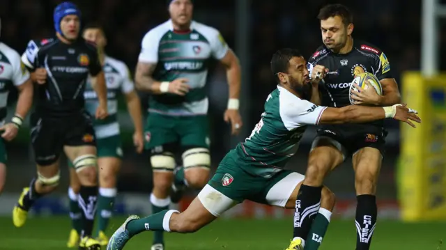 Phil Dollman (R) of Exeter Chiefs is tackled by Telusa Veainu of Leicester Tigers