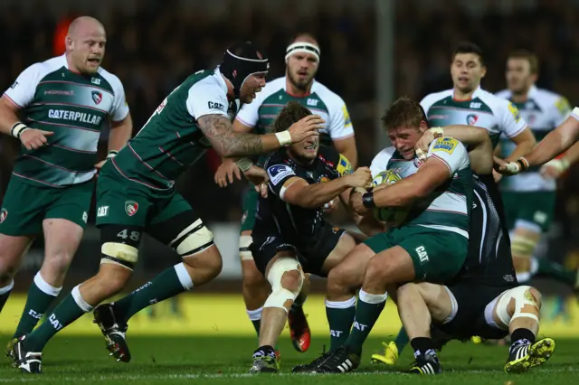 Tom Youngs (C) of Leicester Tigers runs at Mitch Lees (R) of Exeter Chiefs