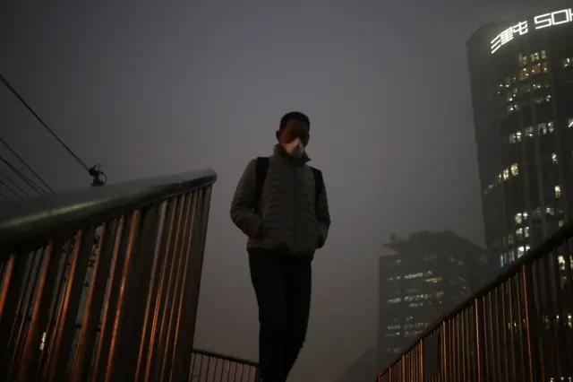 Man in smoggy Beijing wearing a face mask