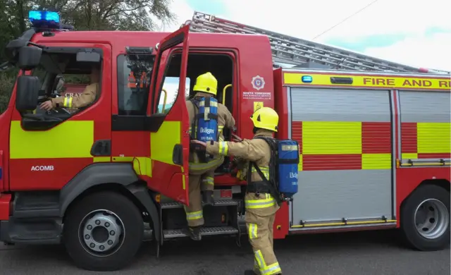 Firemen getting into a fire engine