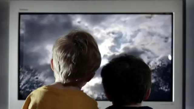 Two young boys watching TV