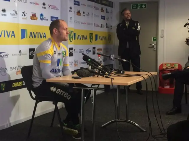 Alex Neil, seated, at the Norwich City press conference