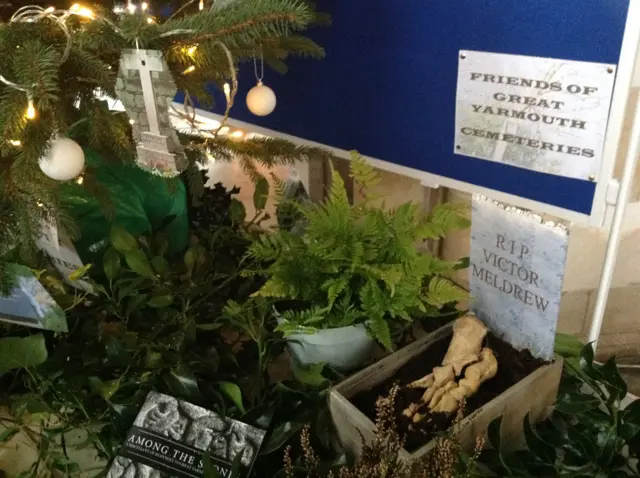 The Christmas tree, showing a skeletal foot in a pretend grave, and a cross on the tree