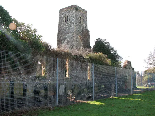 The ruined Hopton church, enclosed by a security fence