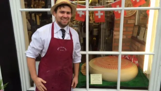 The huge cheese in the window of the deli