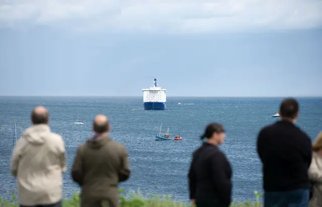 People watching boats on sea