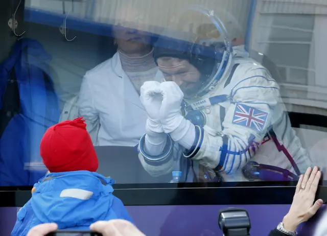 Tim Peake gestures to a child