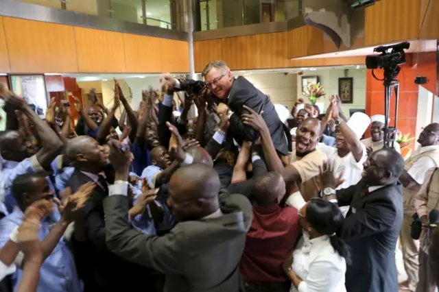 Workers celebrate with Radisson Blu hotel manager Gary Ellis after the hotel reopened in Bamako