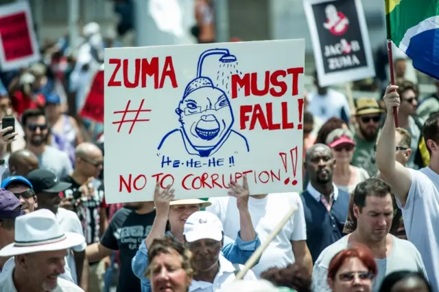 Demonstrators display placards calling for the resignation of South African president as they cross Mandela Bridge in Johannesburg on December 16, 2015