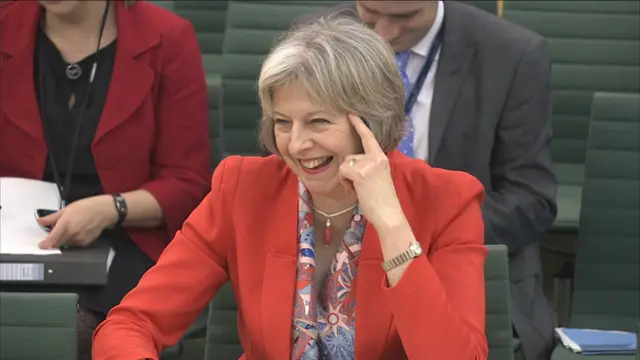 Theresa May smiles as she appears before the Home Affairs Select Committee