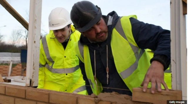 Builder and apprentice laying bricks