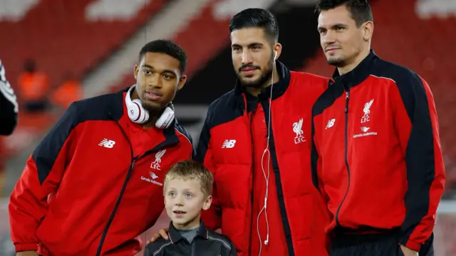 Jordon Ibe, Emre Can and Dejan Lovren pose with a young Liverpool fan ahead of the League Cup quarter-final against Southampton