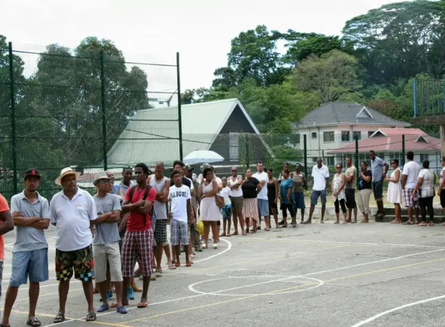 Voters queue outside a polling station as they wait to cast their ballots at Port Louis, in the Seychelles on December 5, 2015 during the presidential ballot