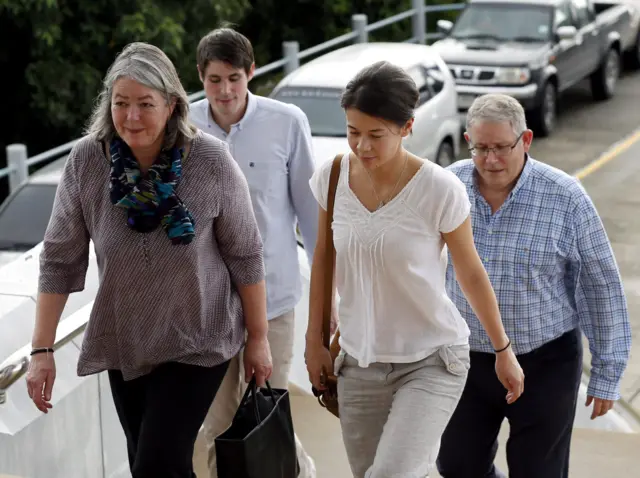 David Miller's family, with an unidentified woman, walk into court