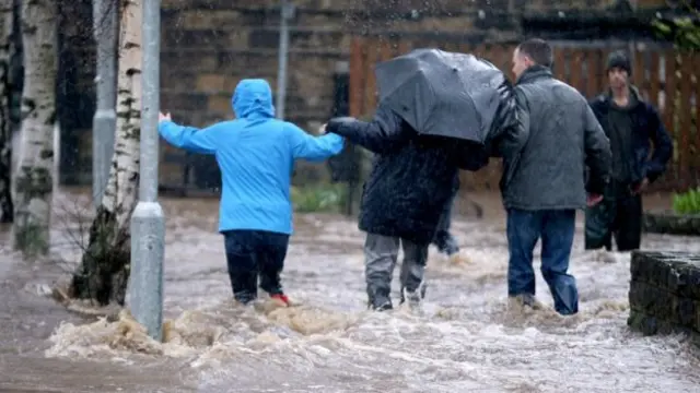 people wading in flood