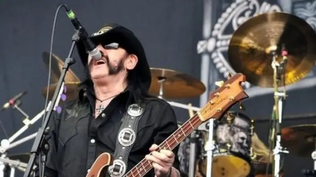 Lemmy singing at microphone with guitar in hand