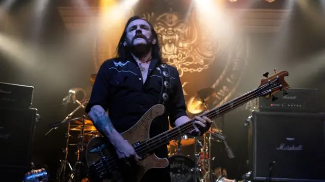 Lemmy with guitar in hand performing