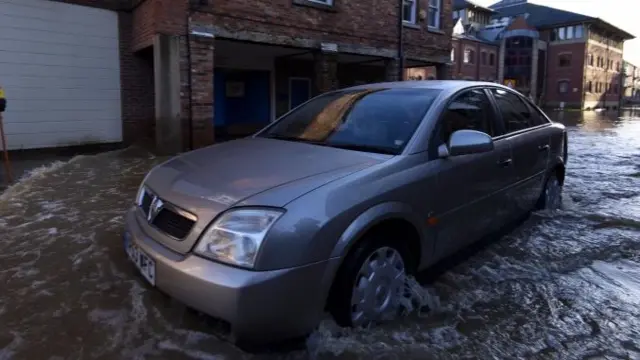 A car drives through floodwaters in Skeldergate in York