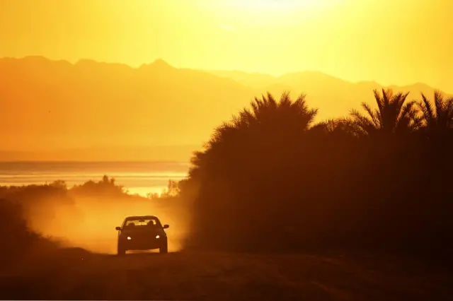 Car driving with sunset in background