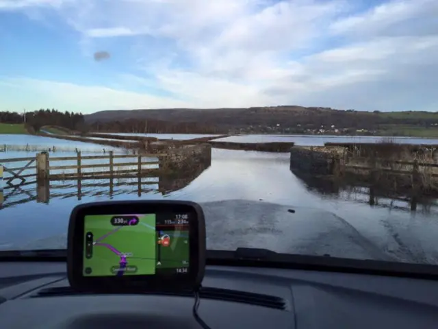 Car pulls up at flooded road