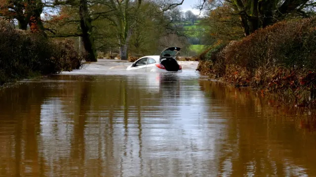 An abandoned car in flood water