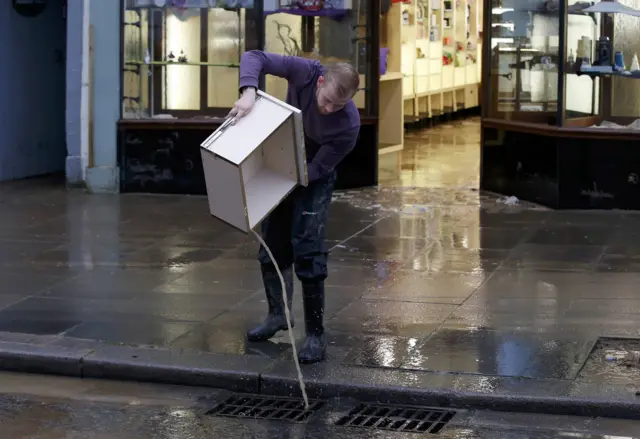 Man emptying water from his shop in Cockermouth