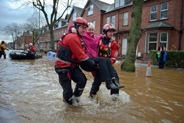 Woman being carried to safety in Carlisle