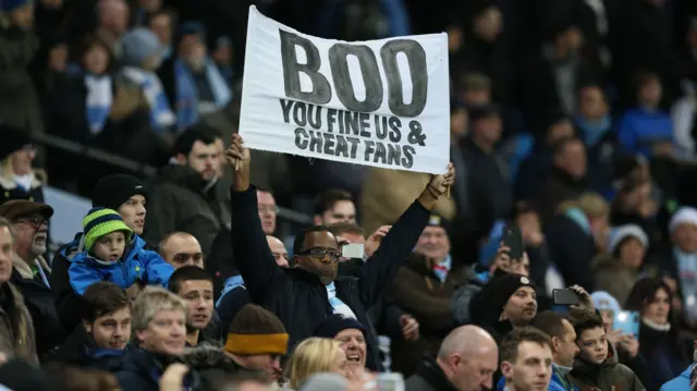 Manchester City fans hold up a banner