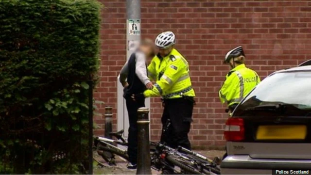 Police officer searching a suspect