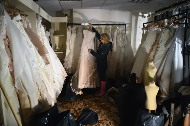 Jacinta Cooper from Kokoabride inspects the damage to bridal dresses