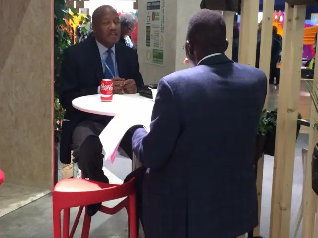 conference attendees reading the new draft at a cafe table