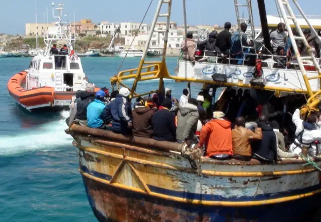 Refugees who flew Libya arrive on a boat on the Italian island of Lampedusa on April 19, 2011