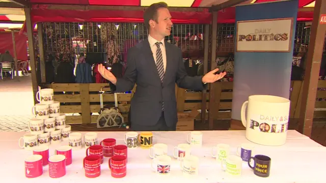 Screengrab from the Daily Politics, showing reporter Adam Fleming offering the public mugs