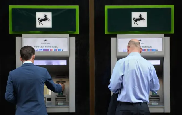 Customers at Lloyds bank ATMs