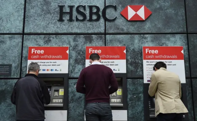 Customers use cash machines at HSBC"s City of London branch