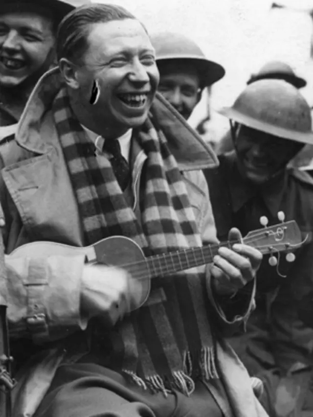 George Formby playing a ukulele